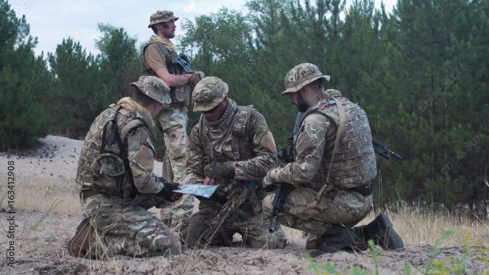 Two soldiers sitting in nature and using map and gps tracker for navigation. Two soldiers sitting in nature and using map and gps tracker for navigation.