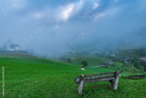 Empty bench overlooking Sorica village in Slovenia photo