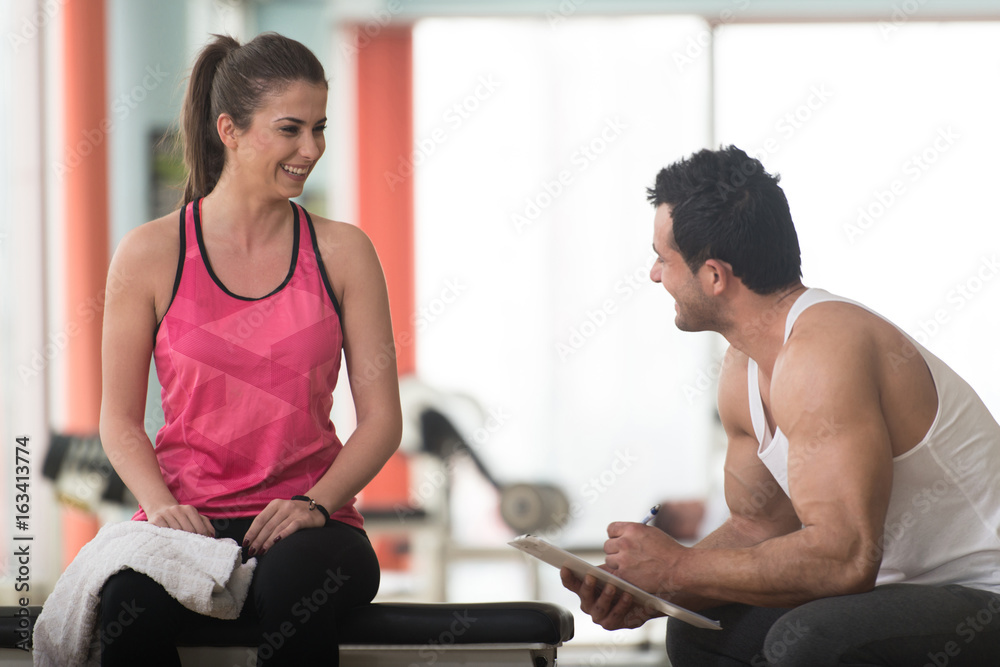 Trainer Takes Notes While Woman Sitting and Resting