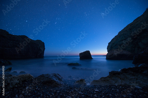 Scenic rocky seashore at sunset under the stars