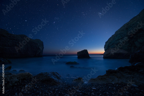 Scenic rocky seashore at sunset under the stars