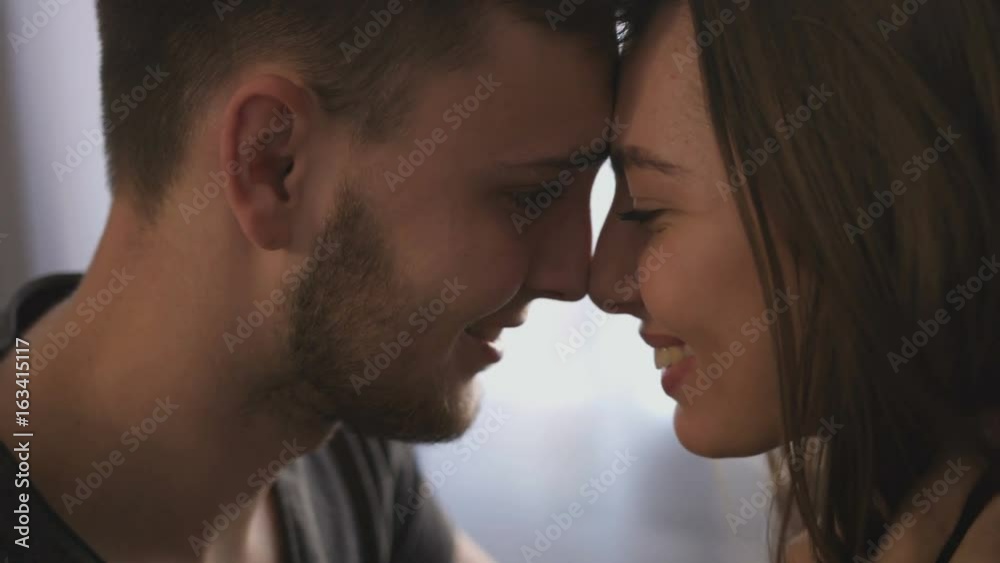 Portrait of attractive loving couple at home in the living room, looking to each others and feeling happy. Portrait of attractive loving couple at home in the living room, looking to each others and feeling happy.