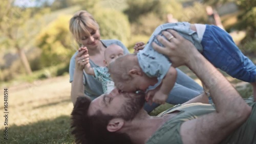 Young parents playing with their little twin sons photo