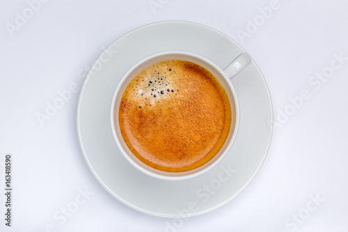 Hot black coffee with foam bubbles in white cup with white background, morning coffee concept.