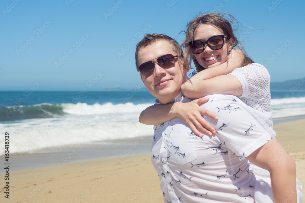Young romantic couple hugging on the beach