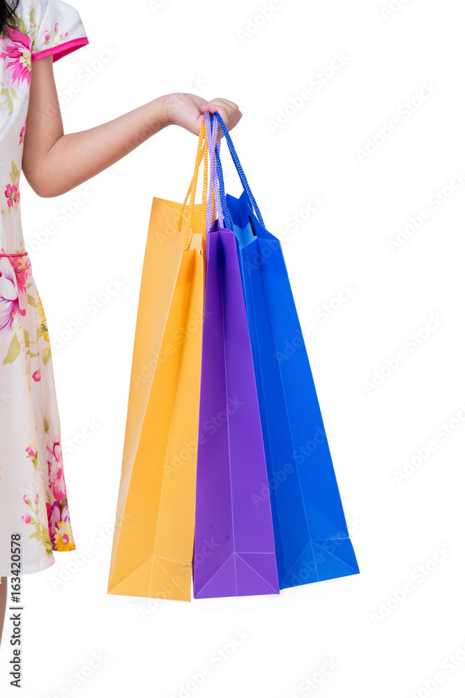 Child's hand holding colorful shopping bags