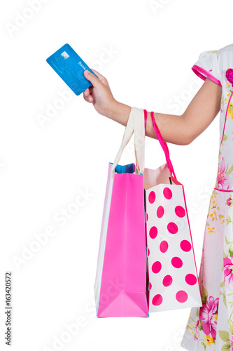 Child's hand holding credit card and colorful shopping bags