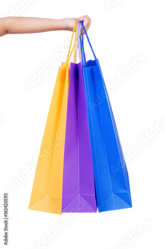 Child's hand holding colorful shopping bags