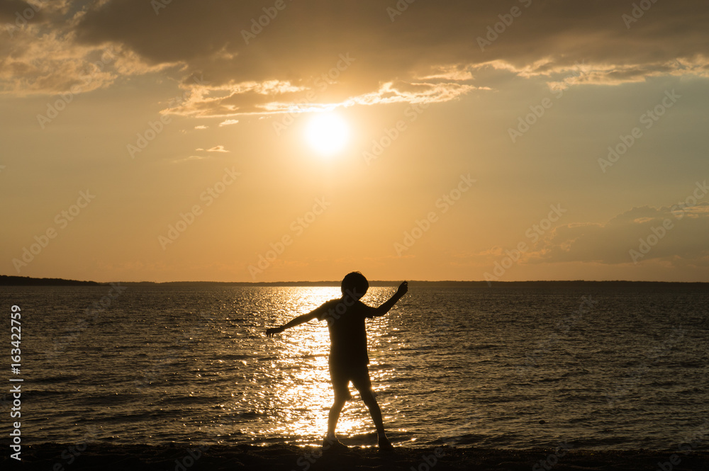 Child throwing rocks on beach
