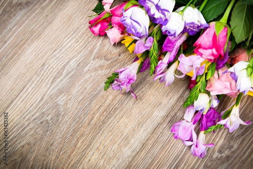 Photo of mixed beautiful flowers on wooden background