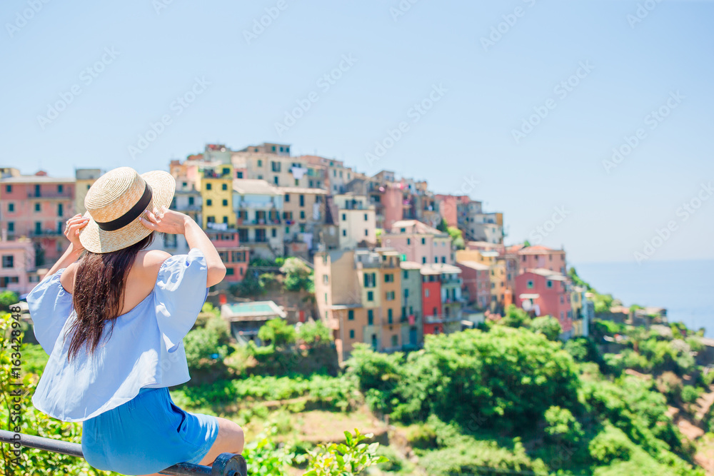 Young woman tourist with beautiful view at old village in Liguria, Italy. European italian vacation.