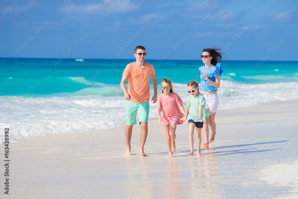 Happy young family with two kids on a tropical beach