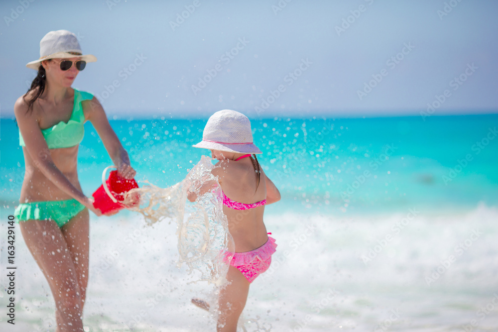 Little adorable girl and young mother having fun at tropical beach Little adorable girl and young mother having fun at tropical beach