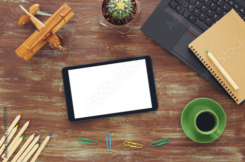 Top view of office work table with leptop, tablet, notebbok and cup of coffee photo