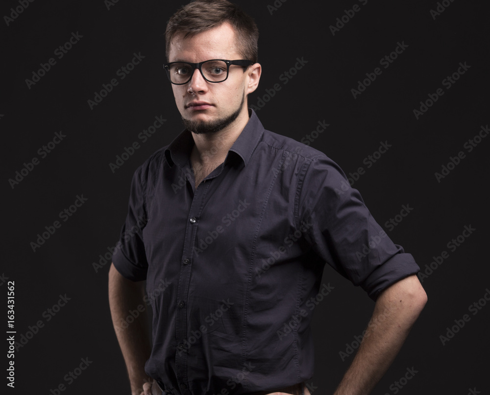 Young confident man portrait of a confident businessman on a black background. Ideal for banners, registration forms, presentation, landings, presenting concept. Young confident man portrait of a confident businessman on a black background. Ideal for banners, registration forms, presentation, landings, presenting concept.