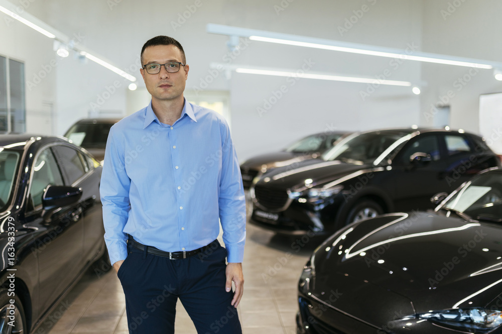 Car dealer standing in his shop Car dealer standing in his shop