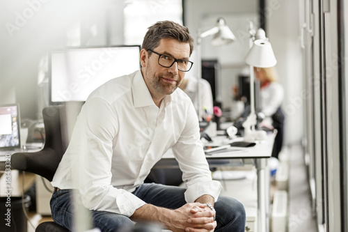 Portrait of businessman at desk in office