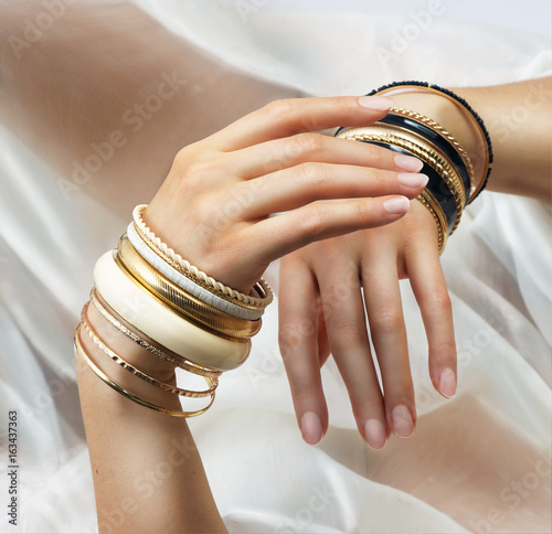Girl’s hands with golden bracelets photo