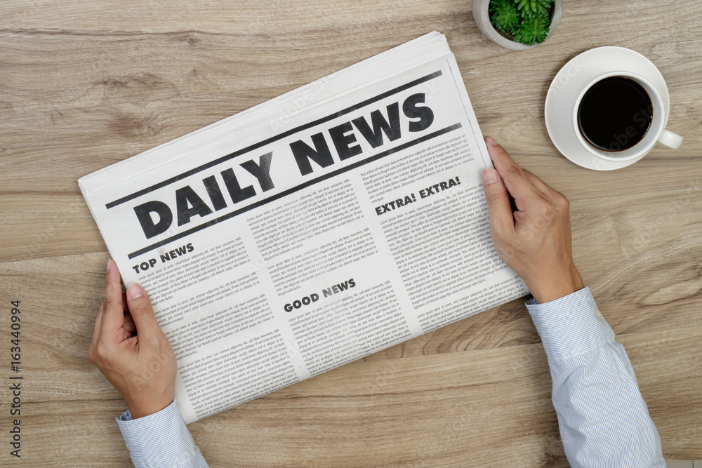 Hand is holding mockup newspapers and coffee cup. Hand is holding mockup newspapers and coffee cup.