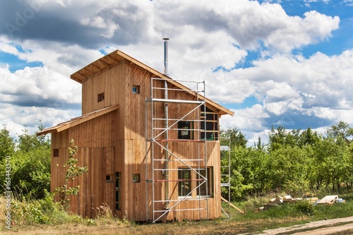 Stainless steel chimney on the building of an ecological home. Energy-saving wooden house. Construction of the cottage near the forest. photo