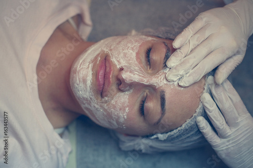 Woman with a facial mask in a spa center. photo