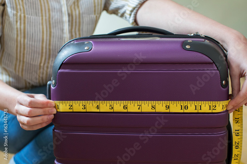 Принти на полотні Close Up Of Woman Measuring Suitcase Before Holiday
