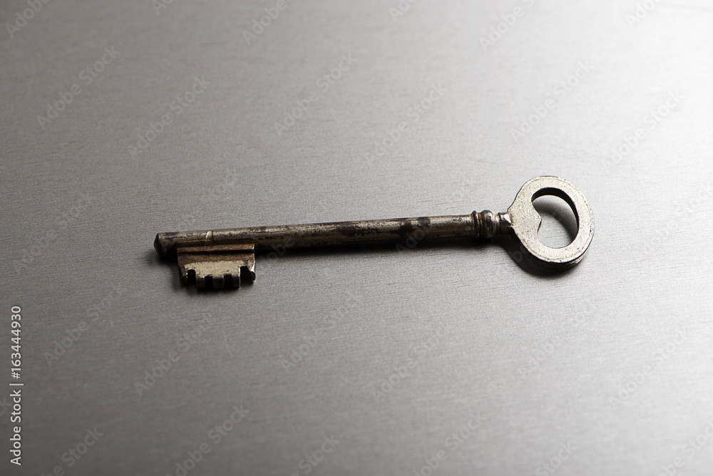 Old key on gray background. Horizontal studio shot