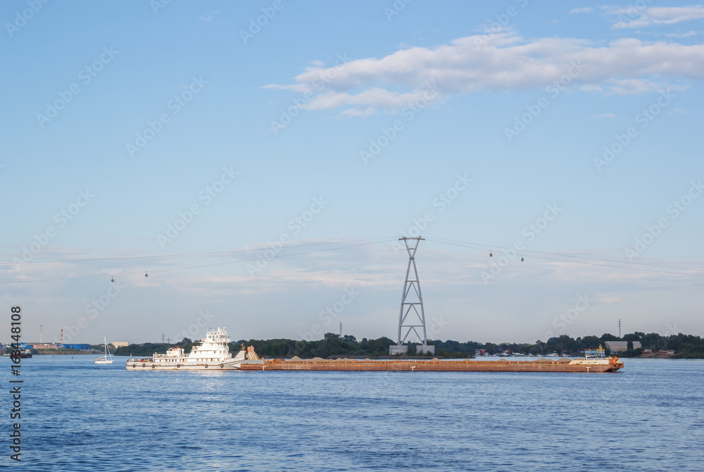 The cargo ship goes on the background of the Nizhny Novgorod cableway