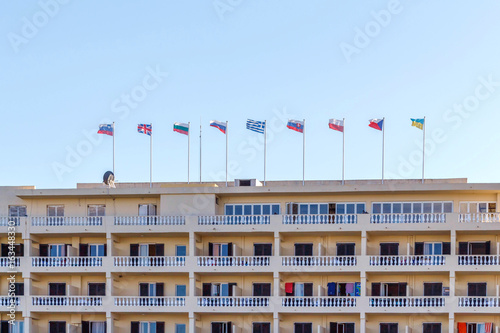 Different countries flags on hotel building. Corfu island, Greece. Daylight photo