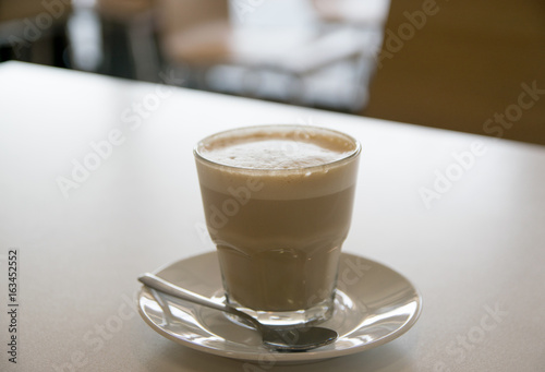 cup of coffee with milk over wooden table
