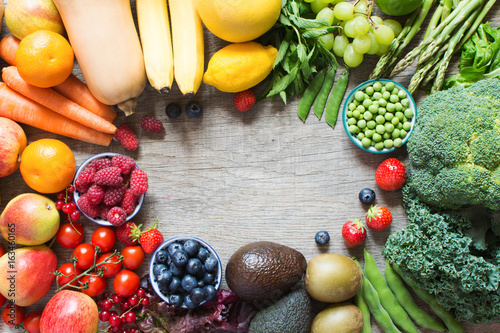 Rainbow fruits and vegetables on the grey wooden table, top view, copy space for text, selective focus