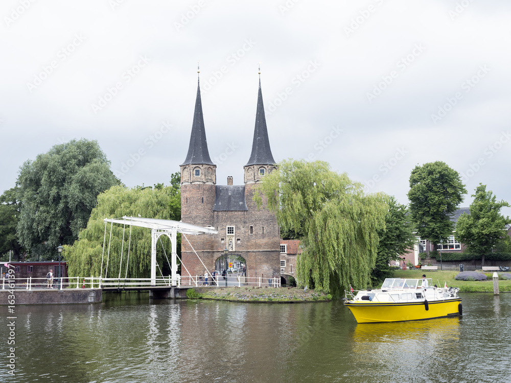 yellow boat waits for bridge to open near oostpoort in old dutch town of delft