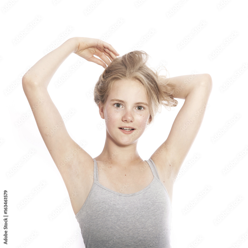 young teen girl holds blond hair up against white background young teen girl holds blond hair up against white background