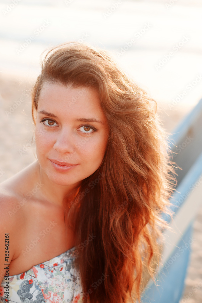 Close-up portrait of a girl with long hair at sunset, she smiles Close-up portrait of a girl with long hair at sunset, she smiles