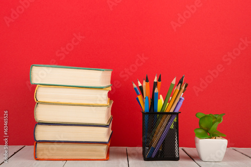 education and wisdom concept - books on wooden table, color background