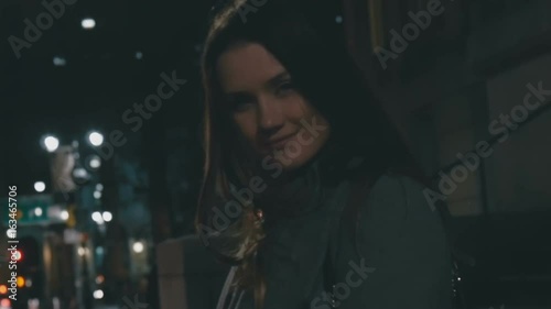 Girl stands at night on the street and looks at the sky close up photo