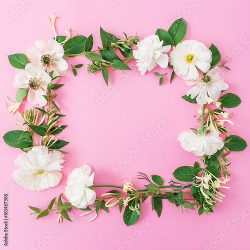 Floral frame of white flowers and leaves on pink background. Floral background. Flat lay, top view.