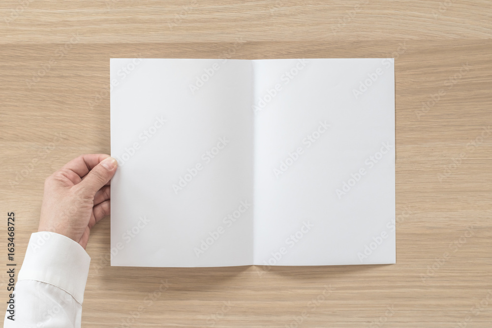 Mock up flyer pamphlet brochure design A5 size paper in business man's hand for template illustration mockup, flat lay on wood table from top view Mock up flyer pamphlet brochure design A5 size paper in business man's hand for template illustration mockup, flat lay on wood table from top view