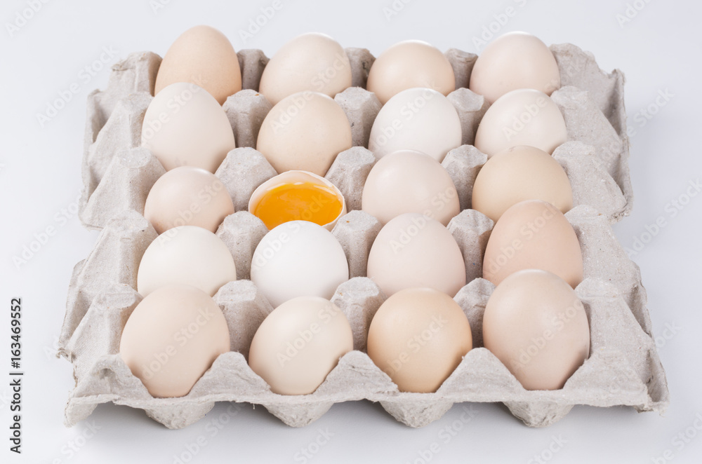 Box filled with eggs, with one broken egg Box filled with eggs, with one broken egg