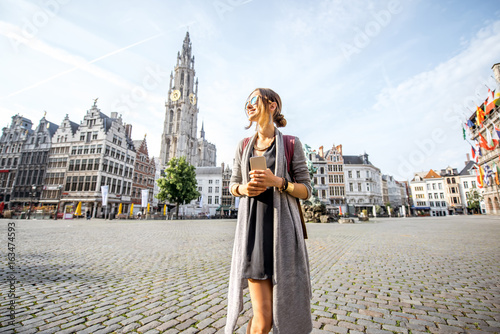 Young woman tourist walking on the Great Market square during the morning in Antwerpen, Belgium photo
