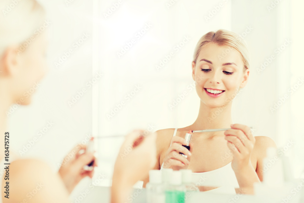 woman with lipstick applying make up at bathroom woman with lipstick applying make up at bathroom