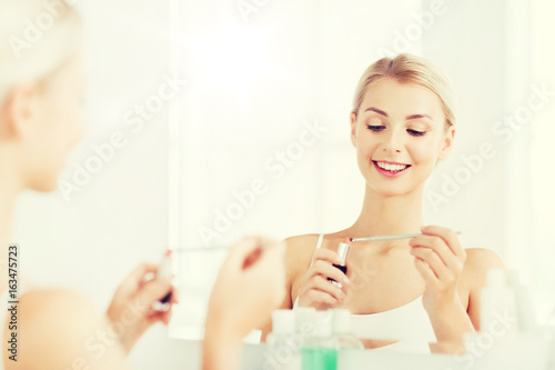 woman with lipstick applying make up at bathroom
