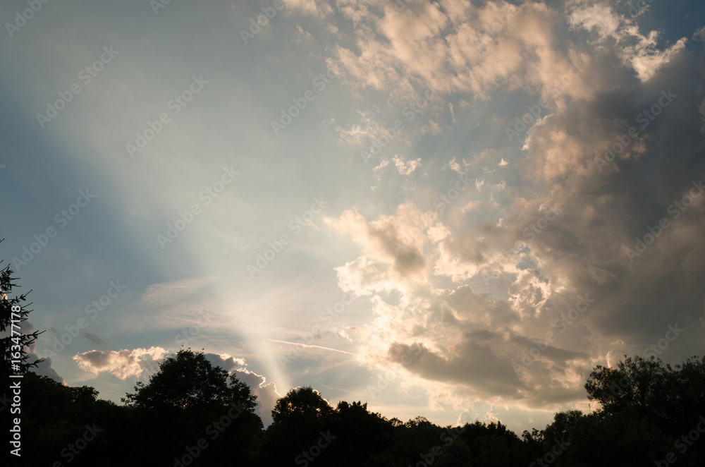 rays of sunlight through clouds outdoor. cloudy sky in summer rays of sunlight through clouds outdoor. cloudy sky in summer