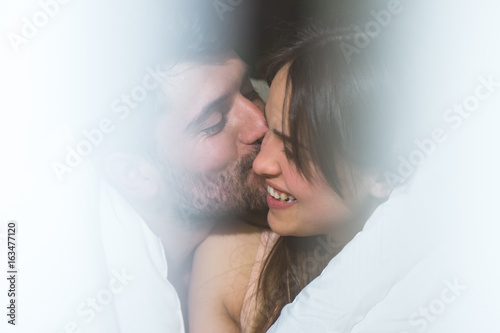 The man kissing a woman in the bed