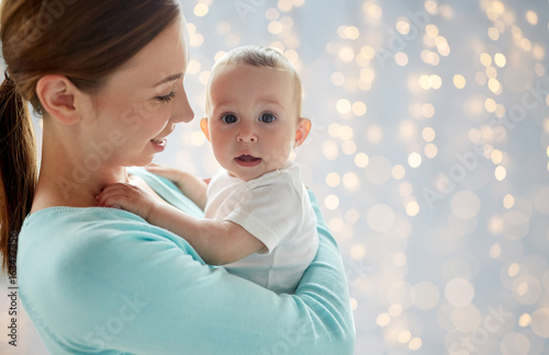 happy young mother with little baby over lights © Syda Productions