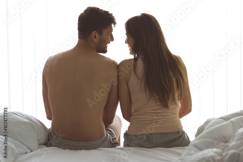 The man and woman sit on the bed
