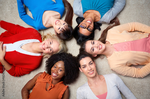 international group of happy women lying on floor