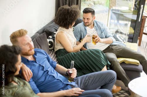 Group of friends watching TV, drinking cider and having fun