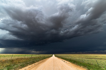 Keuken achterwand Onweer Onverharde weg onder donkere onweerswolken  © JSirlin
