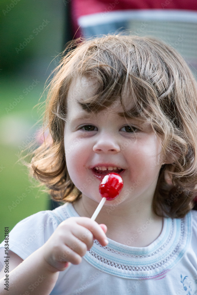 Cute little girl outside with big red lollipop. Cute little girl outside with big red lollipop.